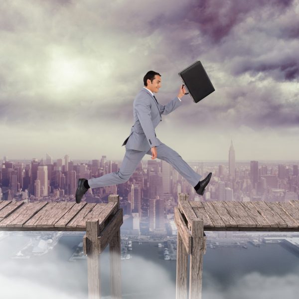 Digital composition of businessman with briefcase jumping on boardwalk against cityscape in background