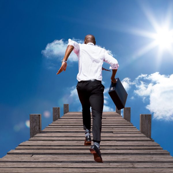 Digital composition of businessman running with briefcase on boardwalk against sky in background