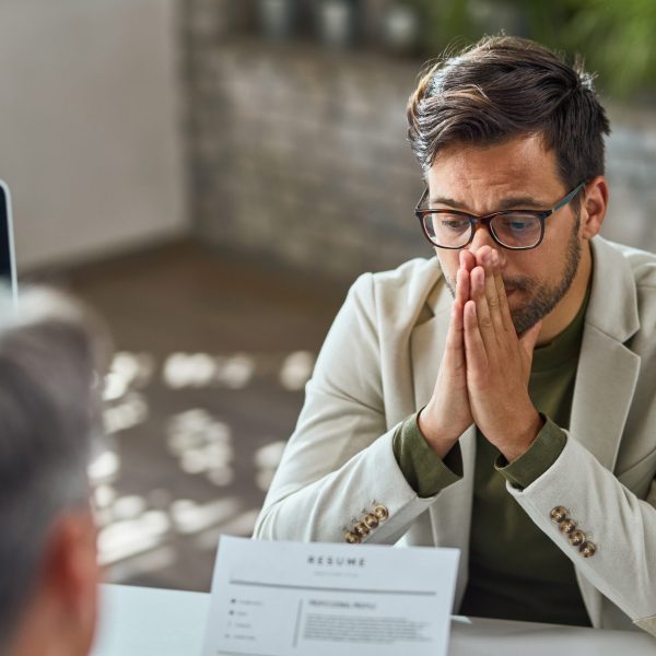 Distraught young man feeling uncertain while having a job interview in the office.